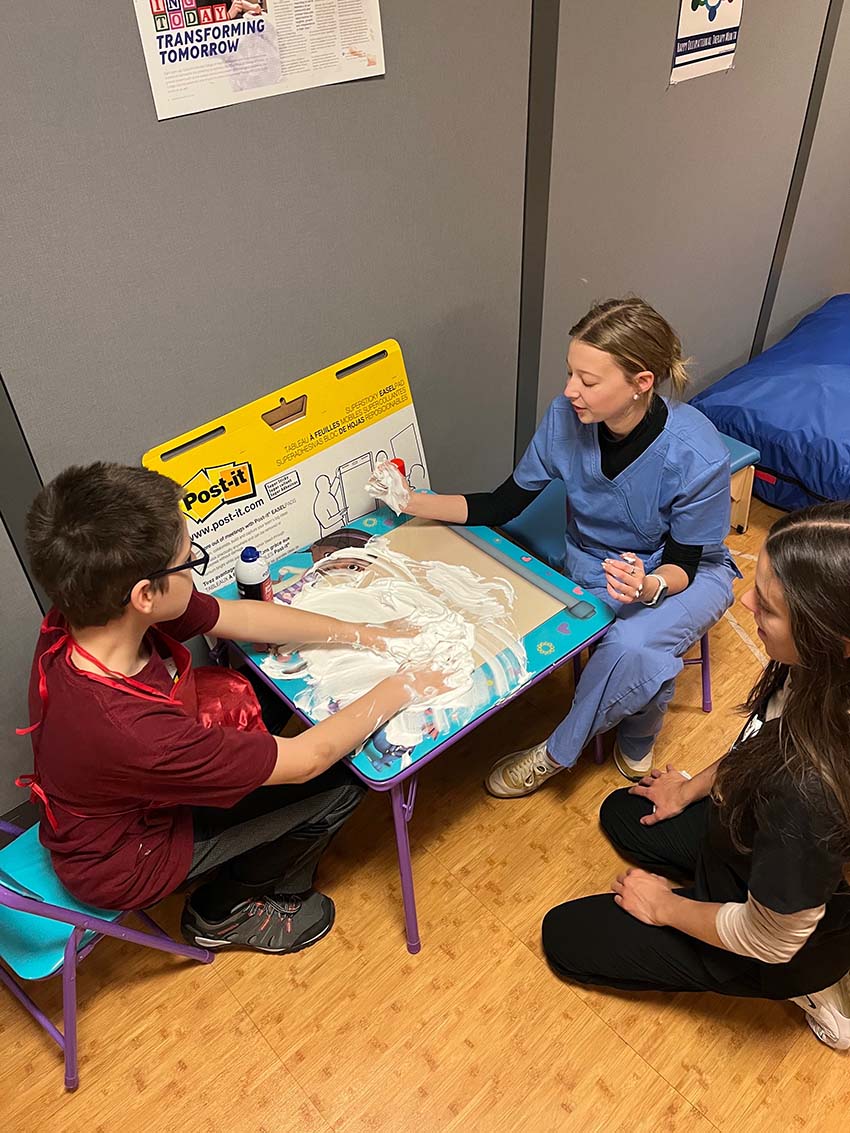 Two OT students writing with shaving cream